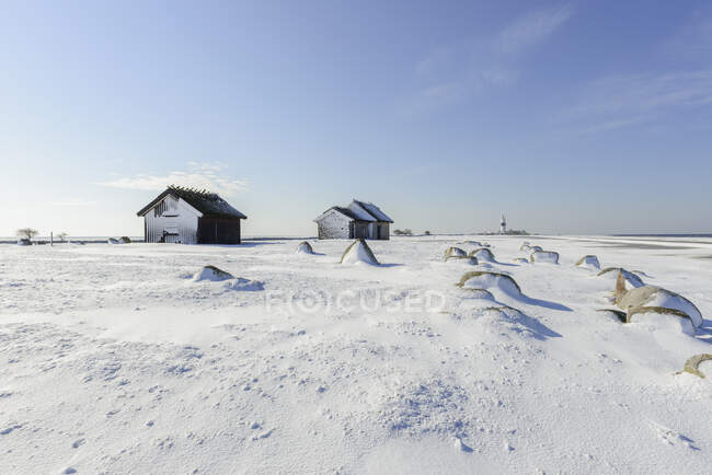 Celeiros em campo coberto de neve durante o dia — Fotografia de Stock