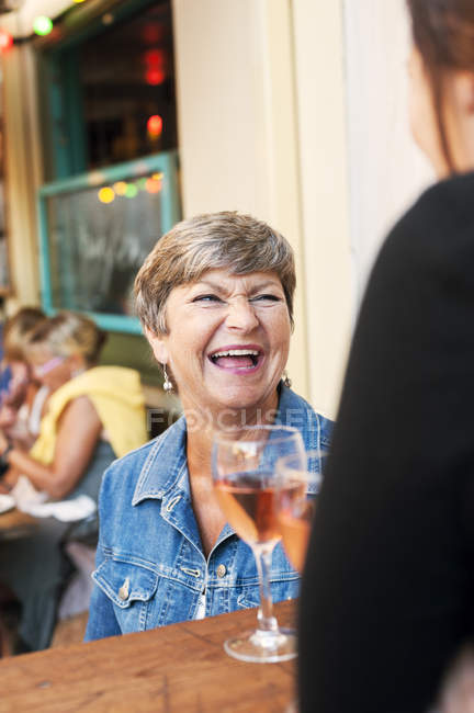 Donna anziana che ride al bar, concentrazione selettiva — Foto stock