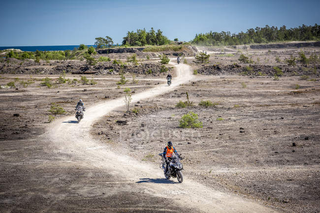Motorcyclists on dirt road, selective focus — Stock Photo