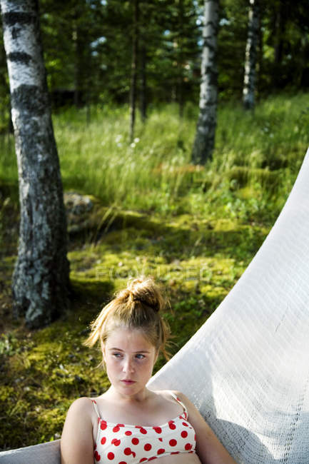 Teenage girl lying in hammock in forest, focus on foreground — Stock Photo