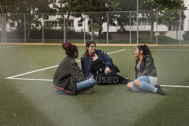 Девочки-подростки сидят на теннисном корте — стоковое фото