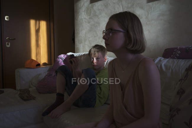 Adolescente menina e menino sentado dentro de casa — Fotografia de Stock