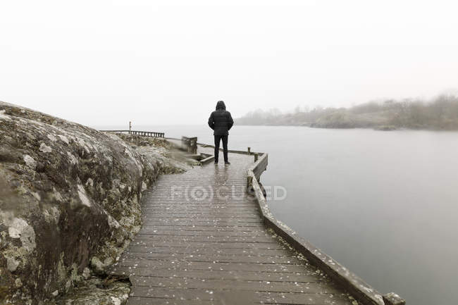 Man on boardwalk by lake, focus selettivo — Foto stock