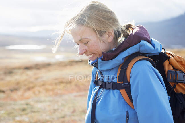 Mulher sorrindo durante caminhada — Fotografia de Stock