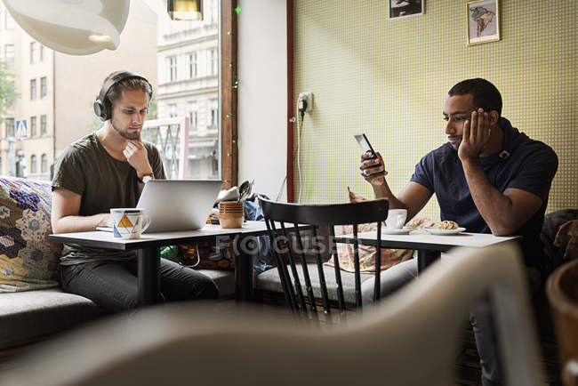 Young men sitting in cafe, selective focus — Stock Photo