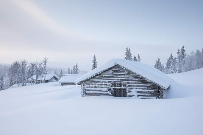 Cabanas de madeira cobertas de neve — Fotografia de Stock