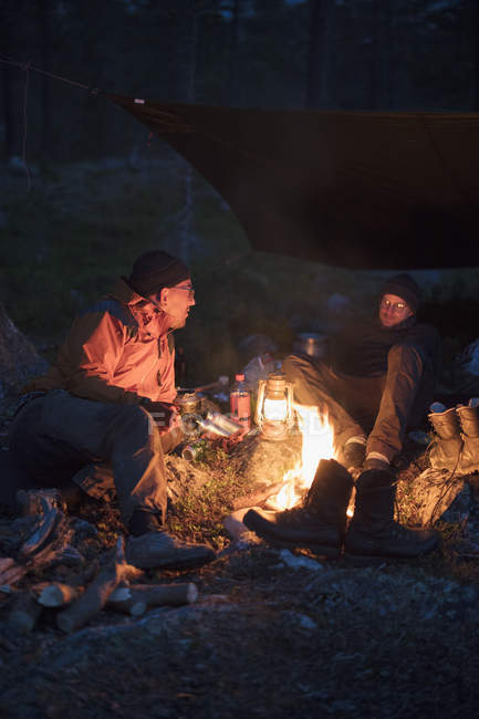 Men by campfire, selective focus — Stock Photo