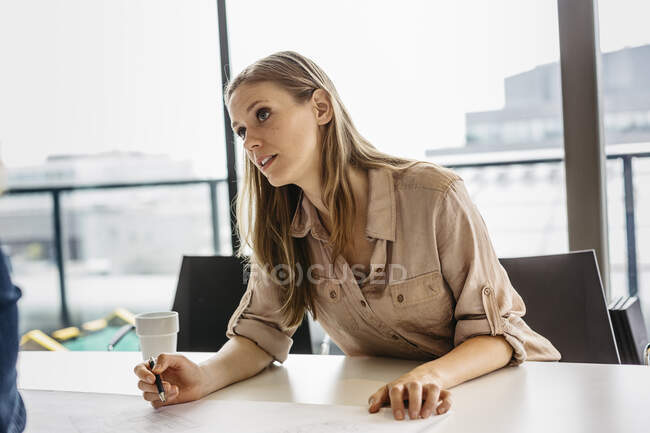 Empresária durante reunião olhando para o lado no escritório — Fotografia de Stock
