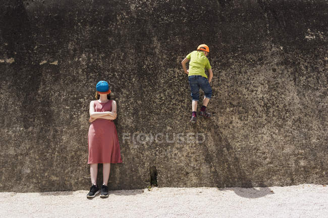 Muralla de escalada y muchacha que se apoya en la pared - foto de stock