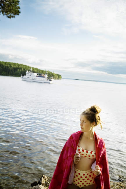 Adolescente envuelta en toalla en la playa - foto de stock