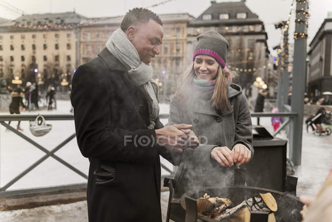 Casal aquecimento mãos sobre fogo, foco seletivo — Fotografia de Stock