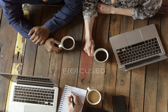 Braços de empresários em mesa de escritório durante reunião — Fotografia de Stock