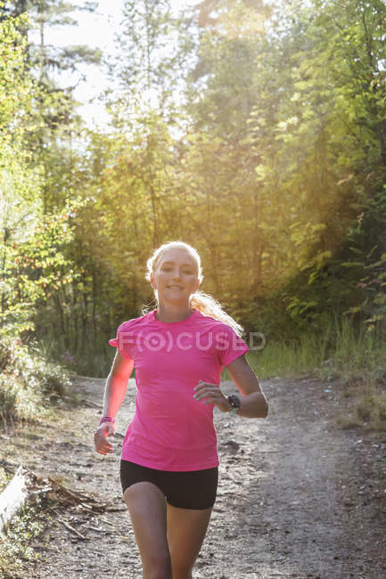 Жінка біжить в лісі, вибірковий фокус — стокове фото