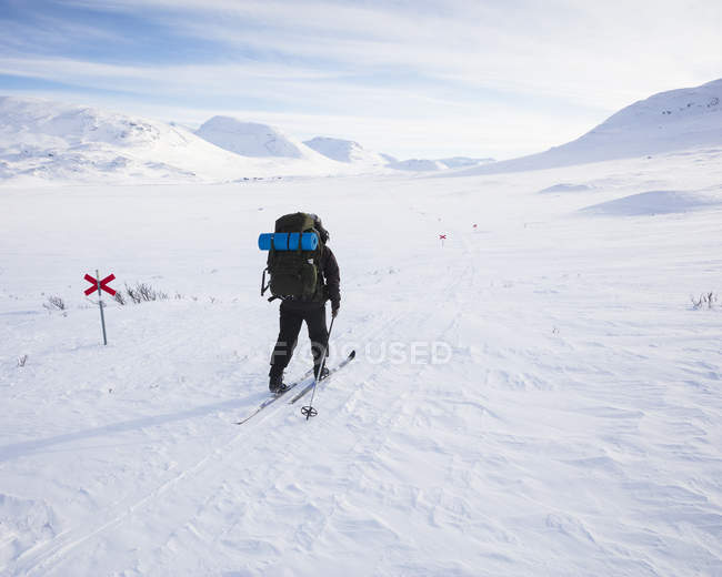 Woman skiing by markers on Kungsleden trail in Lapland, Sweden — Stock Photo