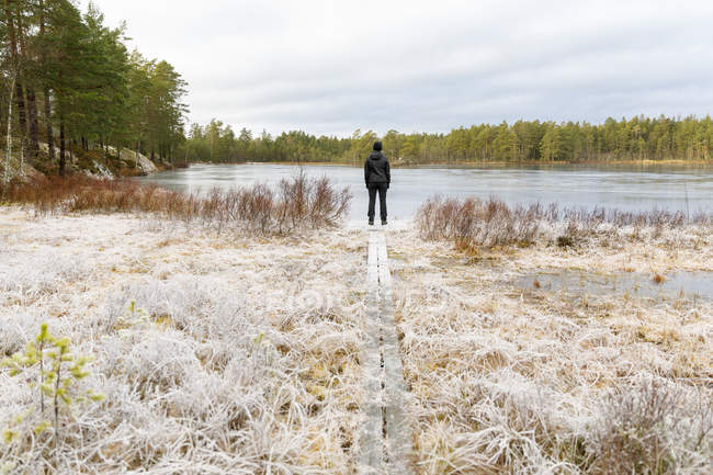 Femme mûre debout devant le lac Lillskiren en Suède — Photo de stock