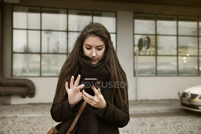 Mujer joven usando el teléfono inteligente, enfoque selectivo - foto de stock