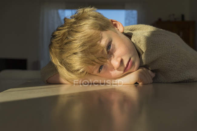 Boy leaning on table, selective focus — Stock Photo
