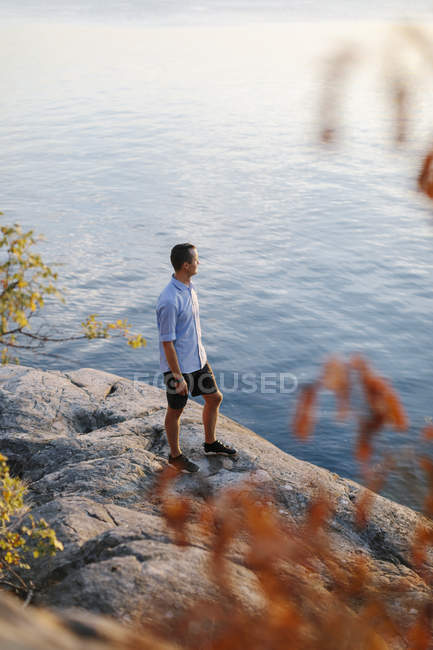 L'uomo in piedi sulla roccia via mare, focus selettivo — Foto stock