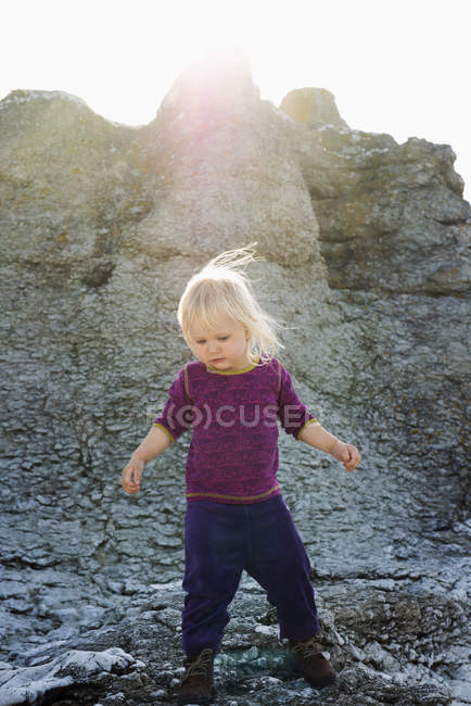 Дівчинка ходить по каменю, зосереджується на вибірці. — стокове фото