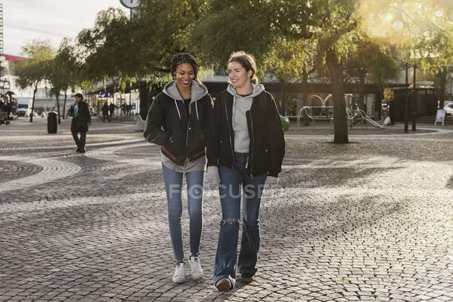Teenage girls walking on cobblestone — Stock Photo