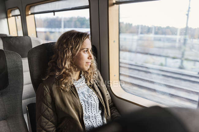 Jeune femme voyageant en train — Photo de stock