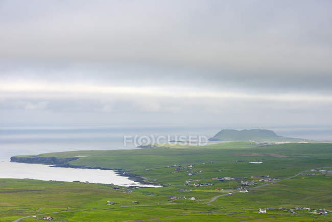 Llanuras verdes por costa oceánica en las Islas Shetland, Reino Unido - foto de stock