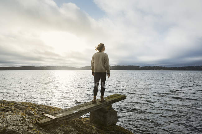 Jeune femme debout à côté du lac — Photo de stock