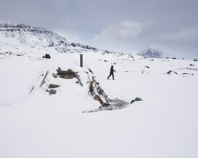 Woman skiing by hut on Kungsleden trail in Lapland, Sweden — Stock Photo