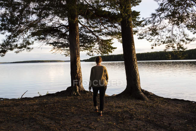 Donna matura che cammina vicino al lago, focus selettivo — Foto stock