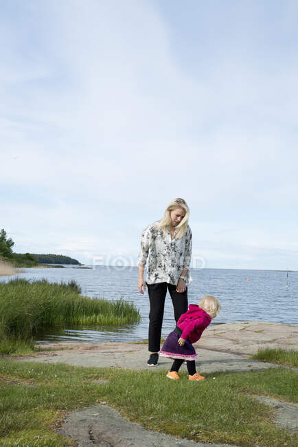 Молода жінка з дочкою біля озера — стокове фото