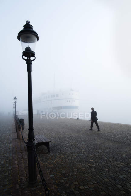 Homem caminhando em dia nebuloso em Estocolmo — Fotografia de Stock
