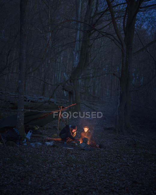 Homens acampando na floresta à noite, foco seletivo — Fotografia de Stock