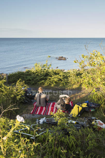 Мужчины, проводящие пикник над морем, избирательный фокус — стоковое фото