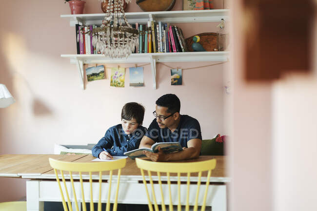 Padre aiutare suo figlio con i compiti — Foto stock
