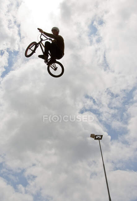 Side view of man doing bmx trick                                       Model Release — Stock Photo
