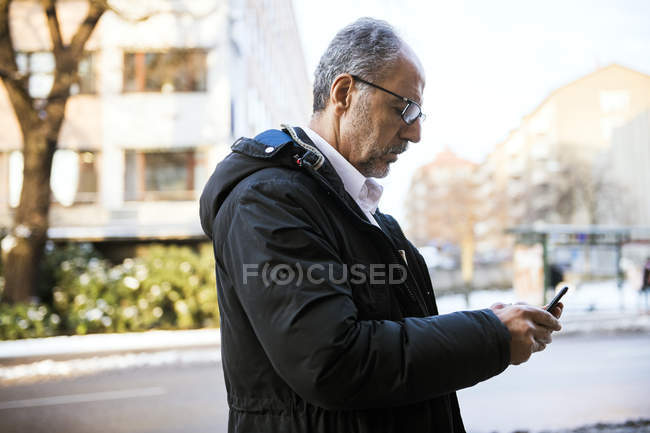 Людина використовує смартфон на відкритому повітрі, вибірковий фокус — стокове фото
