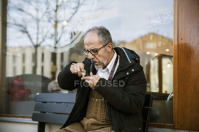 Чоловік курить трубу на вулиці, вибірковий фокус — стокове фото