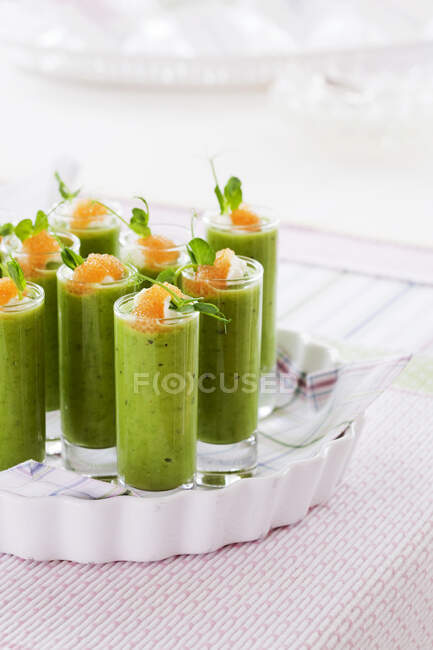 Glasses of pea soup with citrus fruit — Stock Photo