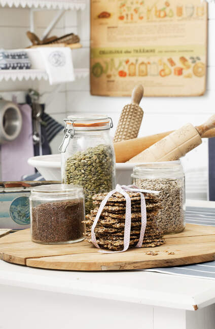 Crispbread with jars of seeds — Stock Photo