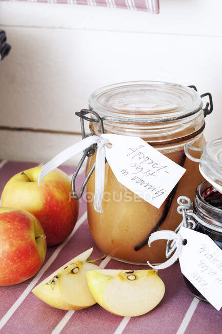 Tarro de mermelada de manzana con manzanas en rodajas - foto de stock