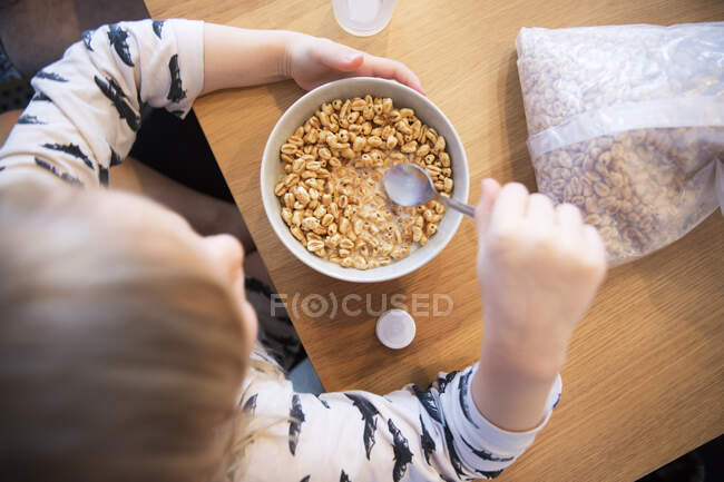 High angle view of girl eating cereal - foto de stock