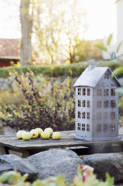 Яблука і будинок тримач свічок на лавці — стокове фото