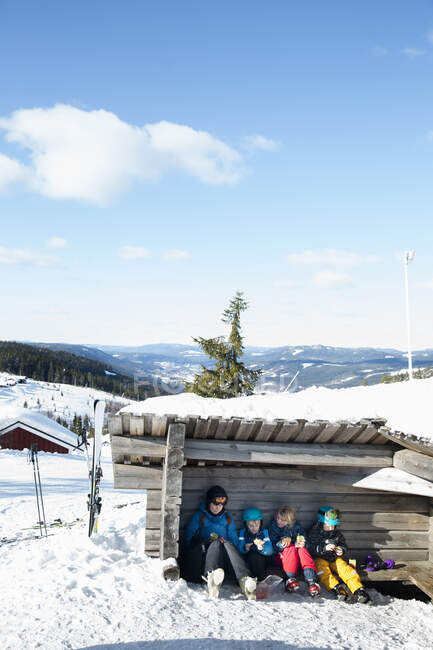 Family taking lunch break at cabin on mountain — Stockfoto