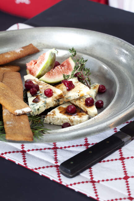 Käse auf Teller mit Trauben, Feigen und Crackern — Stockfoto
