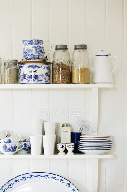 Prateleiras com pratos e frascos de cereais — Fotografia de Stock