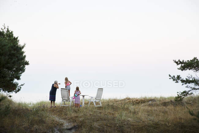 Donna con le nipoti via mare — Foto stock