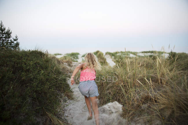 Девушка бежит по песчаному пляжу — стоковое фото