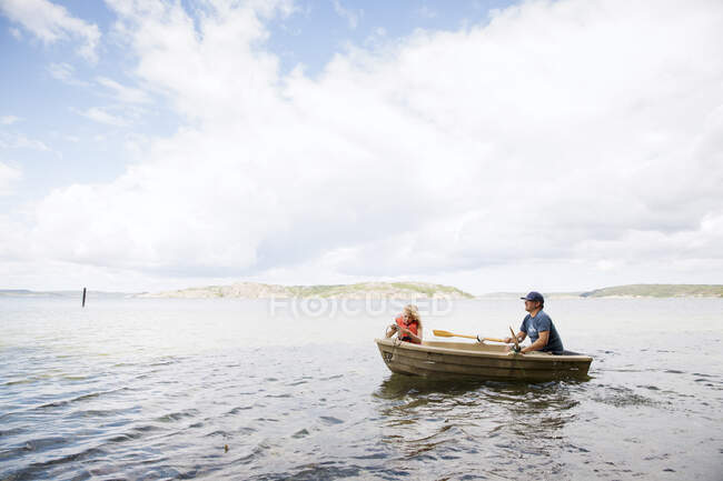 Father and daughter in rowboat on sea - foto de stock