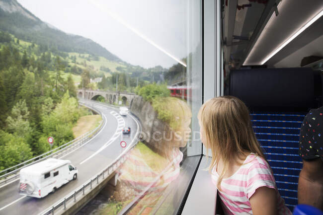 Girl looking out window at highway on train — Fotografia de Stock