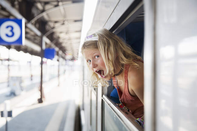 Girl in window of train — Stockfoto